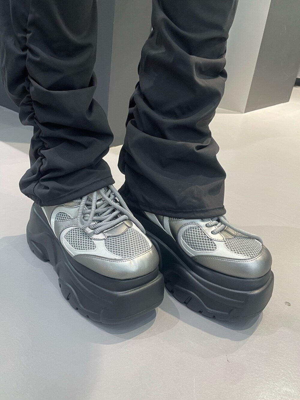 グレー系のニット/セーター、ブルー系のスカート、シルバー系のスニーカーを着用したレディースの冬コーディネートの10枚目の写真