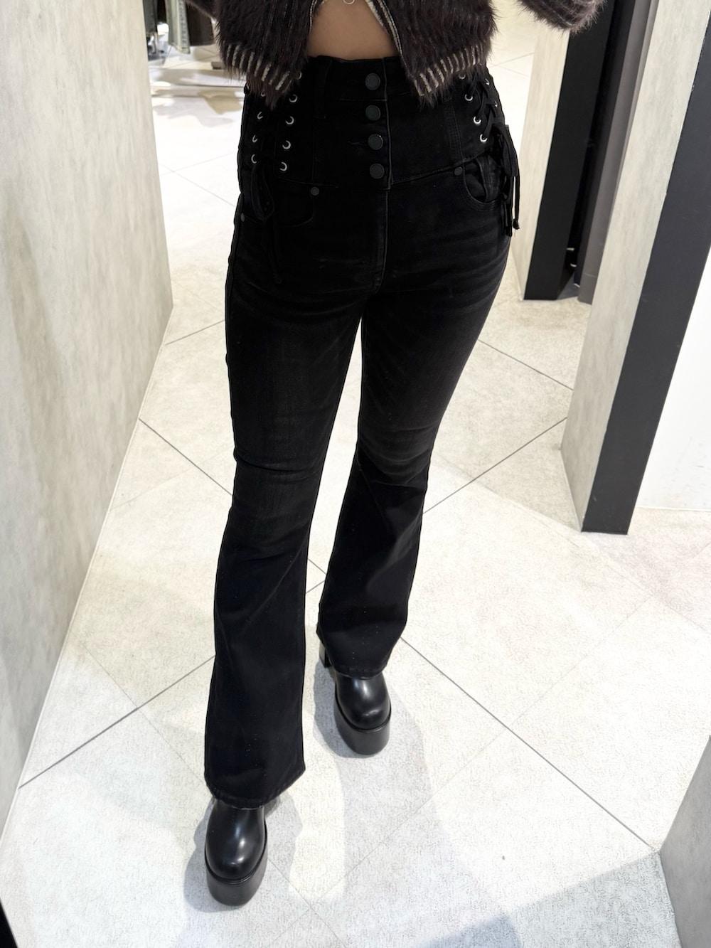 ブラウン系のニット/セーター、ブラック系のデニムパンツ、ブラック系のブーツを着用したレディースの秋コーディネートの6枚目の写真