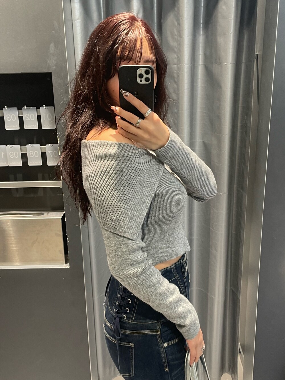 グレー系のニット/セーター、ブルー系のデニムパンツ、シルバー系のショルダーバッグを着用したレディースの冬コーディネートの5枚目の写真