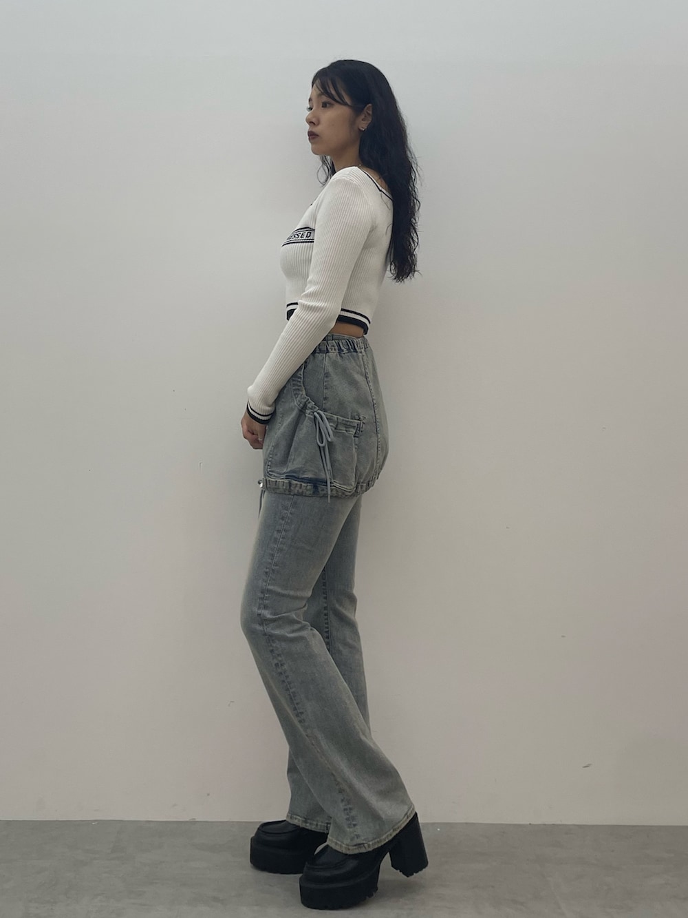 ホワイト系のニット/セーター、ブルー系のデニムパンツ、ブラック系のローファーを着用したレディースの夏コーディネートの2枚目の写真