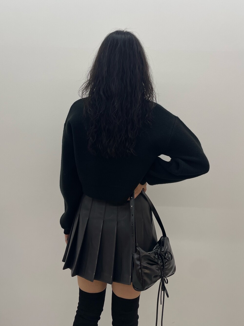 ブラック系のニット/セーター、グレー系のスカート、ブラック系のショルダーバッグを着用したレディースの夏コーディネートの6枚目の写真