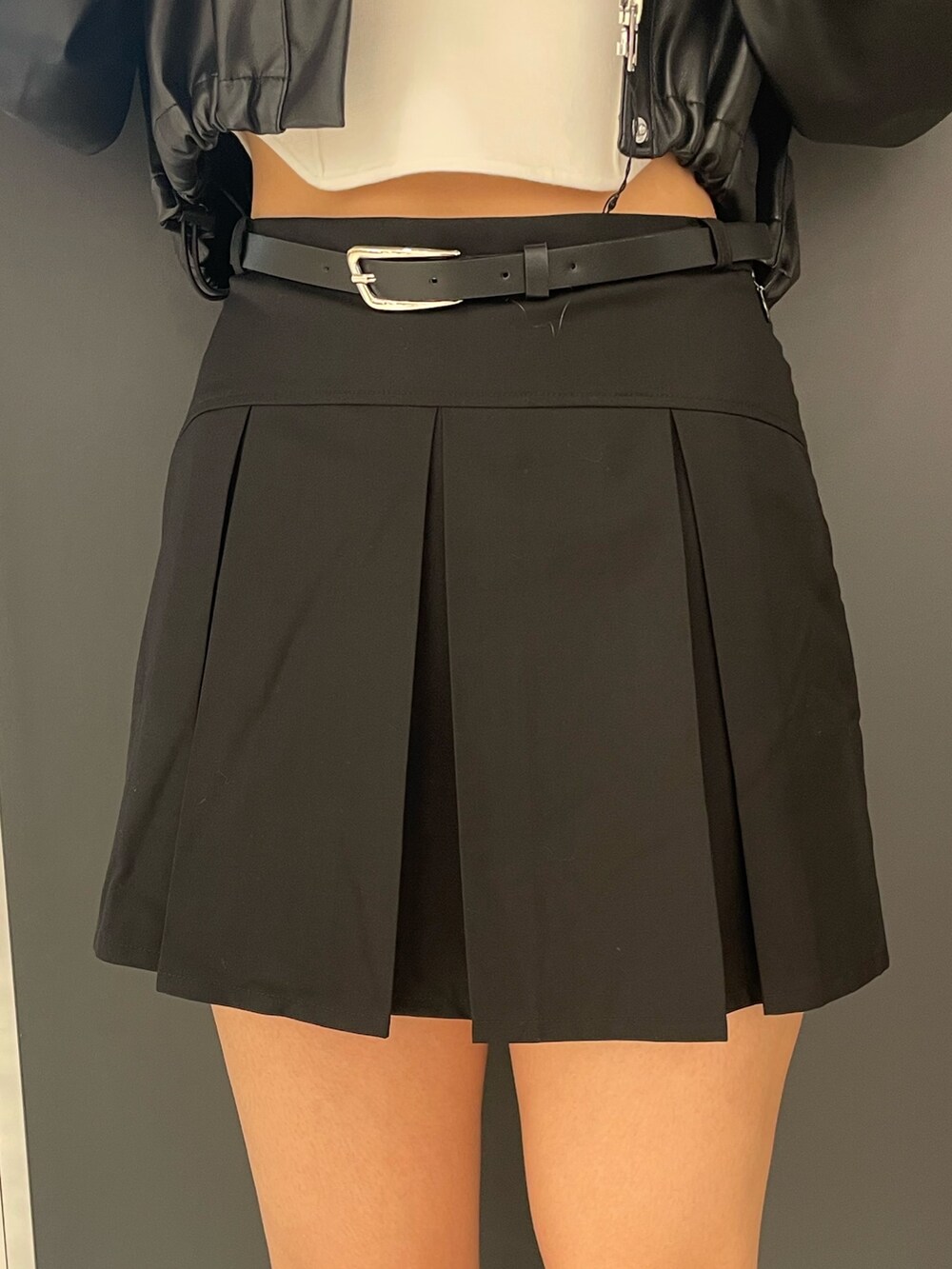 ホワイト系のタンクトップ、ブラック系のブルゾン、ブラック系のスカートを着用したレディースの春コーディネートの7枚目の写真