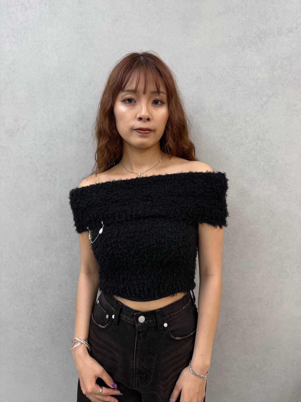 ブラック系のニット/セーター、ブラック系のデニムパンツ、ブラウン系のサンダルを着用したレディースの夏コーディネートの4枚目の写真