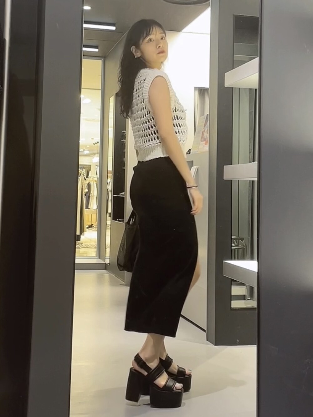 ホワイト系のタンクトップ、ブラック系のワンピース、ブラック系のサンダルを着用したレディースの夏コーディネートの2枚目の写真