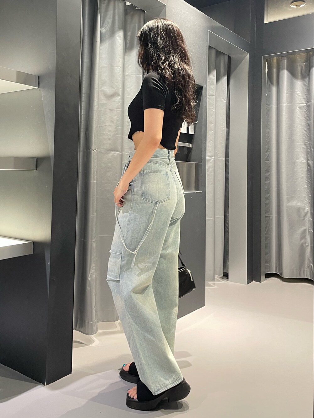 ブラック系のTシャツ/カットソー、ブルー系のデニムパンツ、ブラック系のショルダーバッグを着用したレディースの夏コーディネートの2枚目の写真