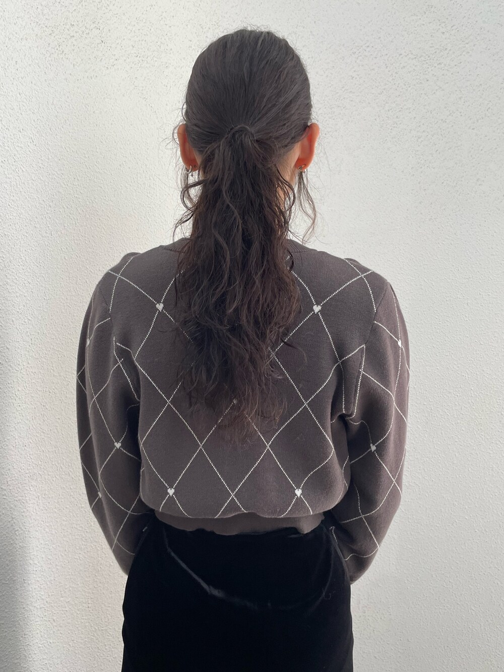 グレー系のニット/セーター、ブラック系のハンドバッグ、ブラック系のスカートを着用したレディースの秋コーディネートの6枚目の写真