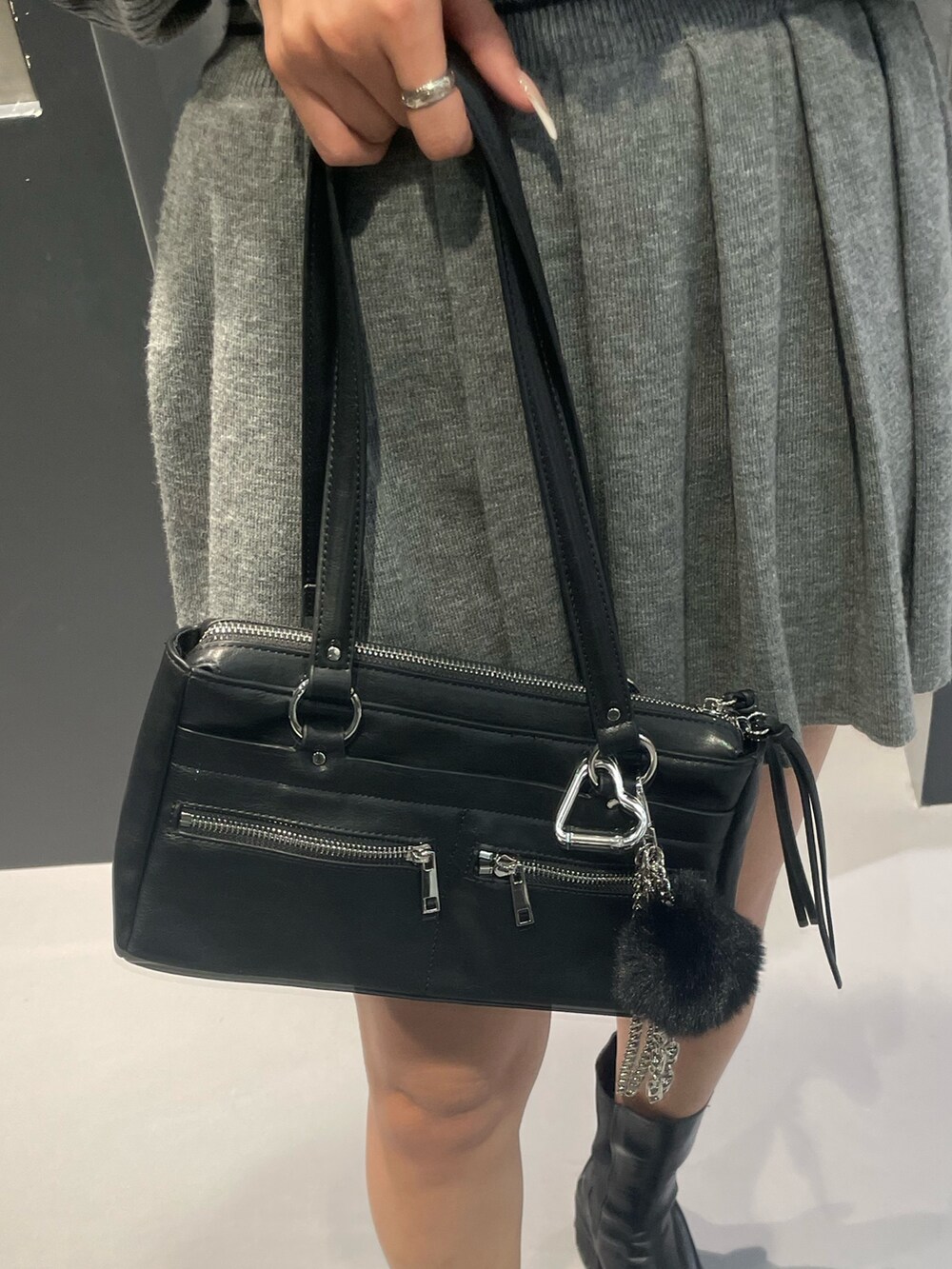 グレー系のニット/セーター、グレー系のスカート、ブラック系のショルダーバッグを着用したレディースの冬コーディネートの8枚目の写真
