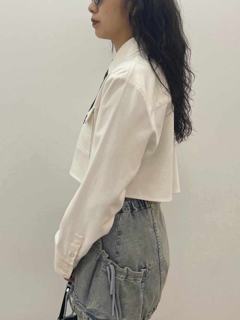 ホワイト系のシャツ/ブラウス、ブルー系のデニムパンツ、ブラック系のショルダーバッグを着用したレディースの夏コーディネートの5枚目の写真