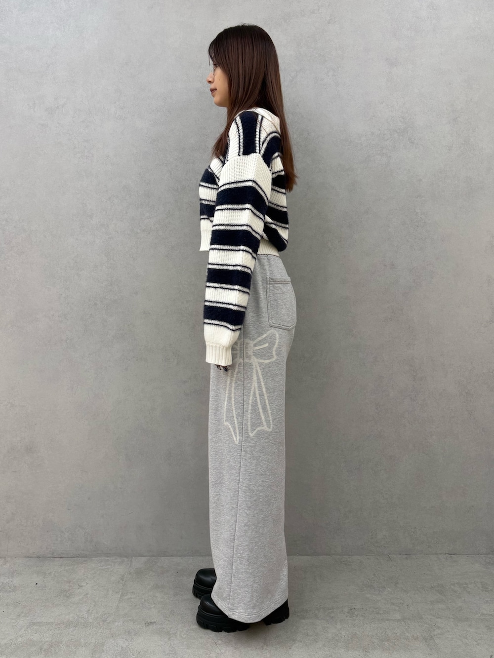 ブルー系のニット/セーター、グレー系のスウェットパンツ、ブラック系のブーツを着用したレディースの冬コーディネートの2枚目の写真