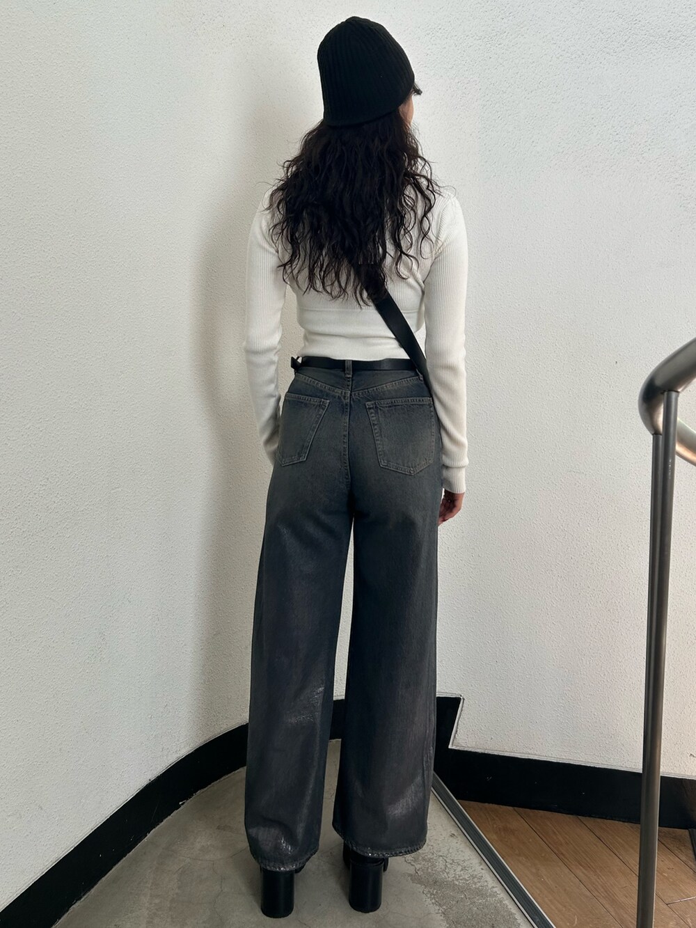 ホワイト系のニット/セーター、ブラック系のハンドバッグ、ブルー系のデニムパンツを着用したレディースの秋コーディネートの3枚目の写真