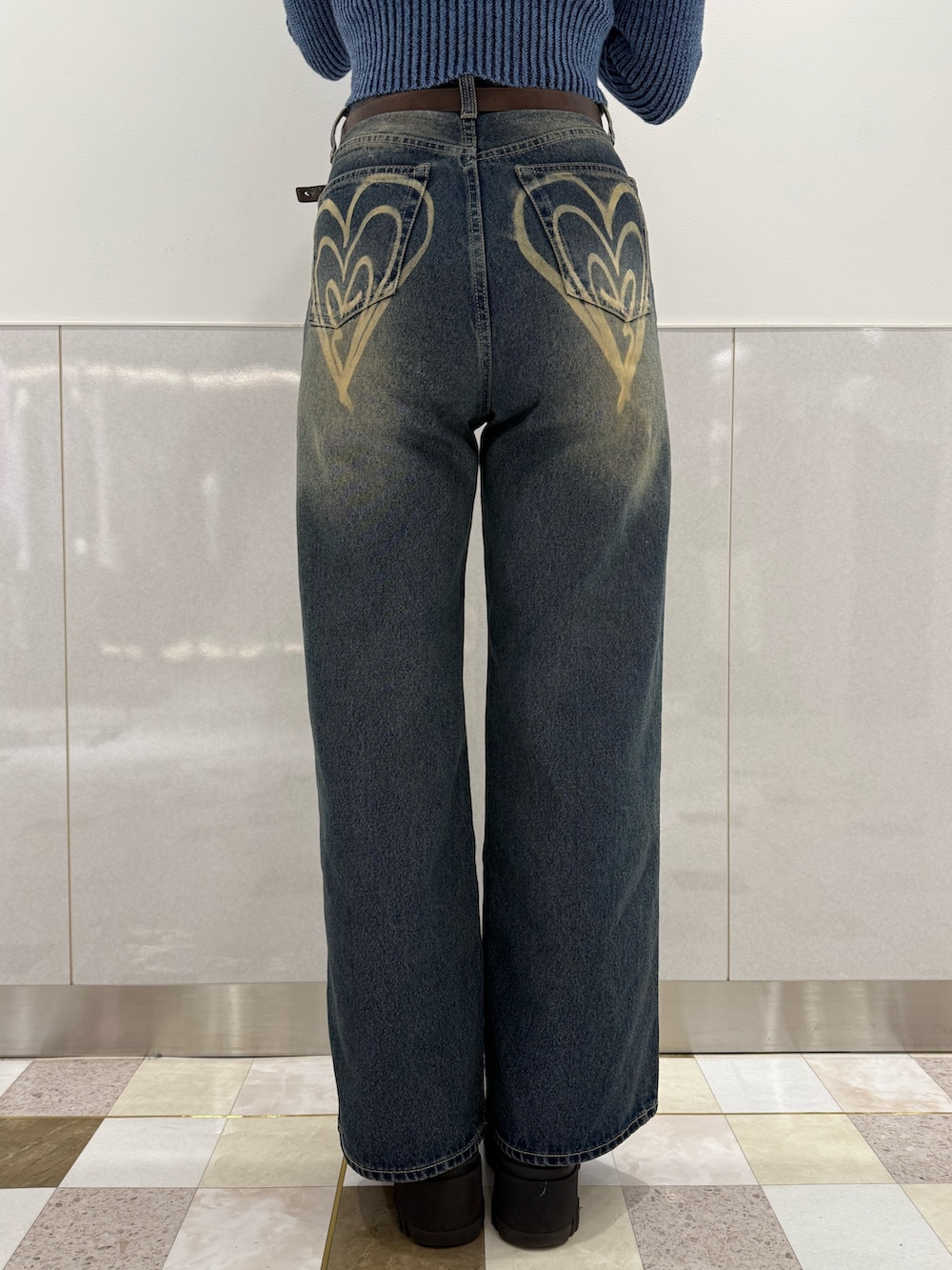 ブルー系のニット/セーター、ブルー系のデニムパンツ、ブラック系のブーツを着用したレディースの冬コーディネートの7枚目の写真