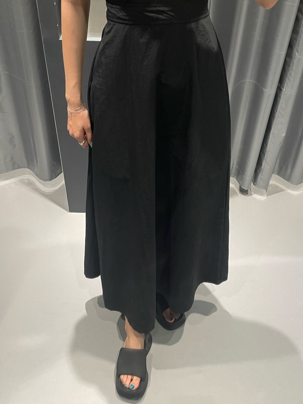 ブラック系のワンピース、ブラック系のサンダル、シルバー系のネックレスを着用したレディースの夏コーディネートの6枚目の写真