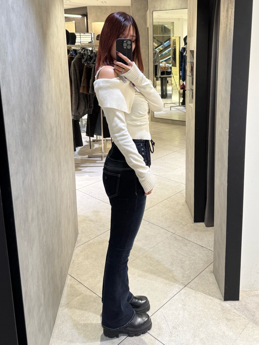 ホワイト系のニット/セーター、ブルー系のデニムパンツ、ブラック系のブーツを着用したレディースの秋コーディネートの2枚目の写真