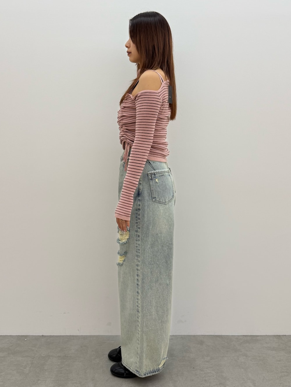 ピンク系のニット/セーター、ブルー系のデニムパンツ、ブラック系のスニーカーを着用したレディースの冬コーディネートの2枚目の写真