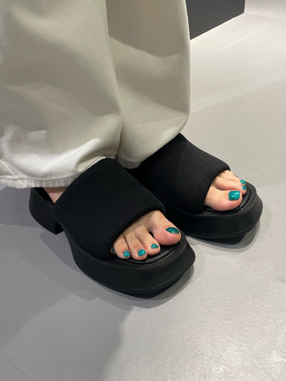 ブラック系のワンピース、ブラック系のサンダル、シルバー系のネックレスを着用したレディースの夏コーディネートの8枚目の写真