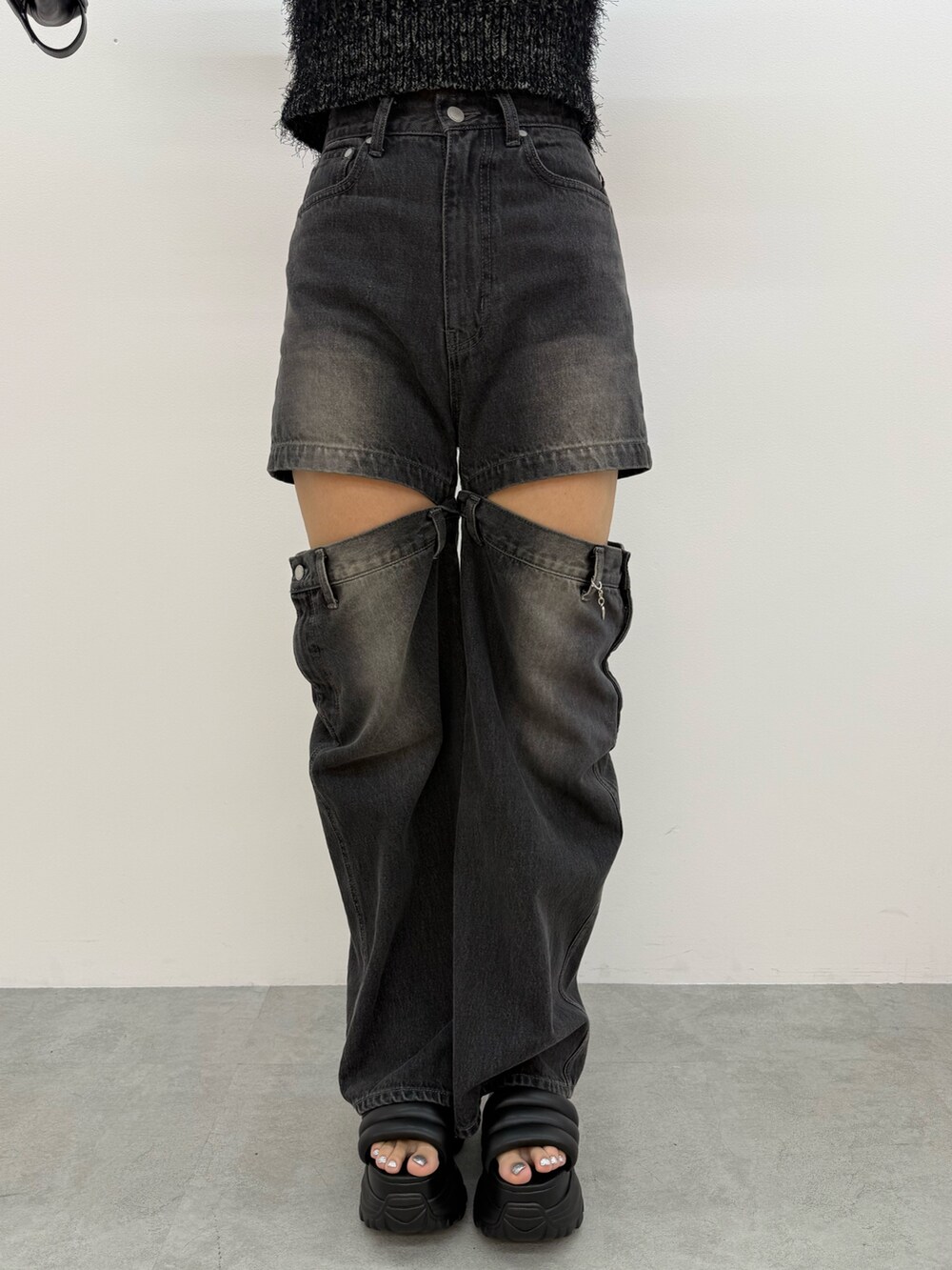 ブラック系のニット/セーター、ブラック系のデニムパンツ、ブラック系のサンダルを着用したレディースの夏コーディネートの7枚目の写真