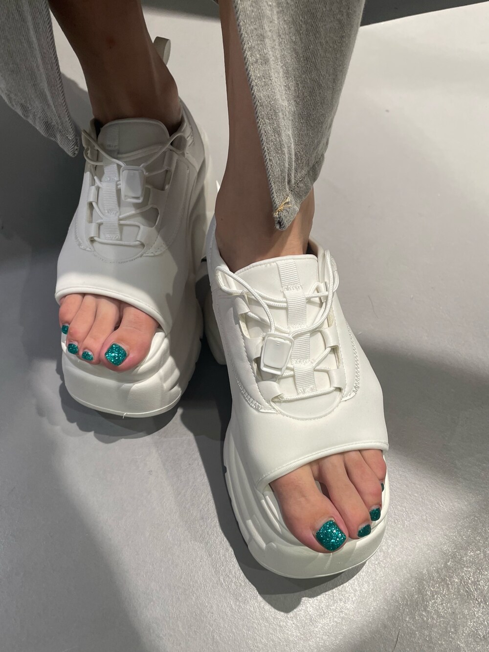 ブルー系のTシャツ/カットソー、グレー系のデニムスカート、ホワイト系のサンダルを着用したレディースの夏コーディネートの8枚目の写真