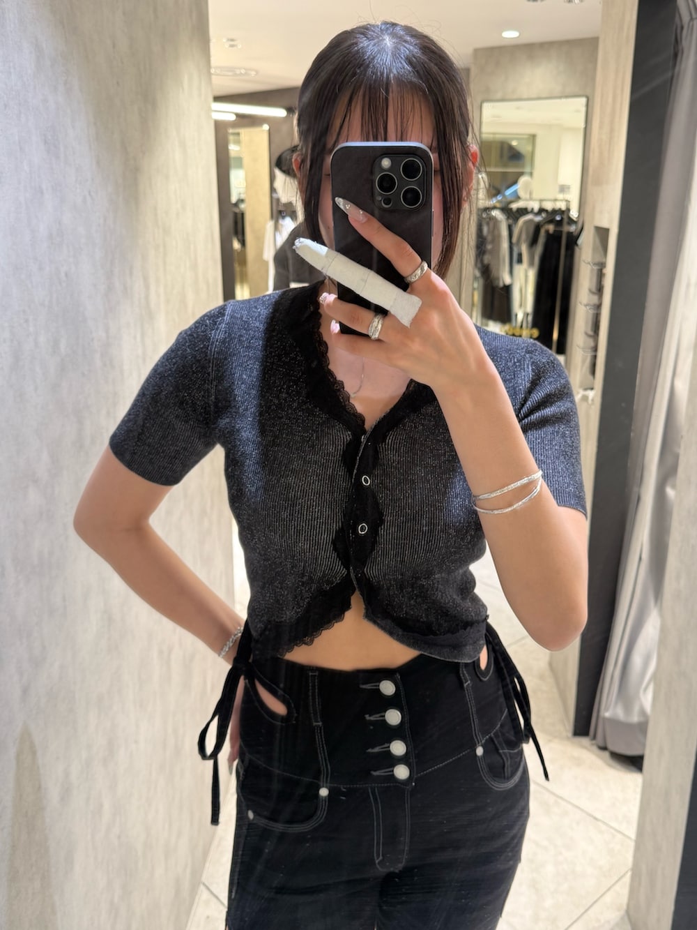 ブラック系のニット/セーター、ブラック系のデニムパンツ、ブラック系のサンダルを着用したレディースの春コーディネートの4枚目の写真
