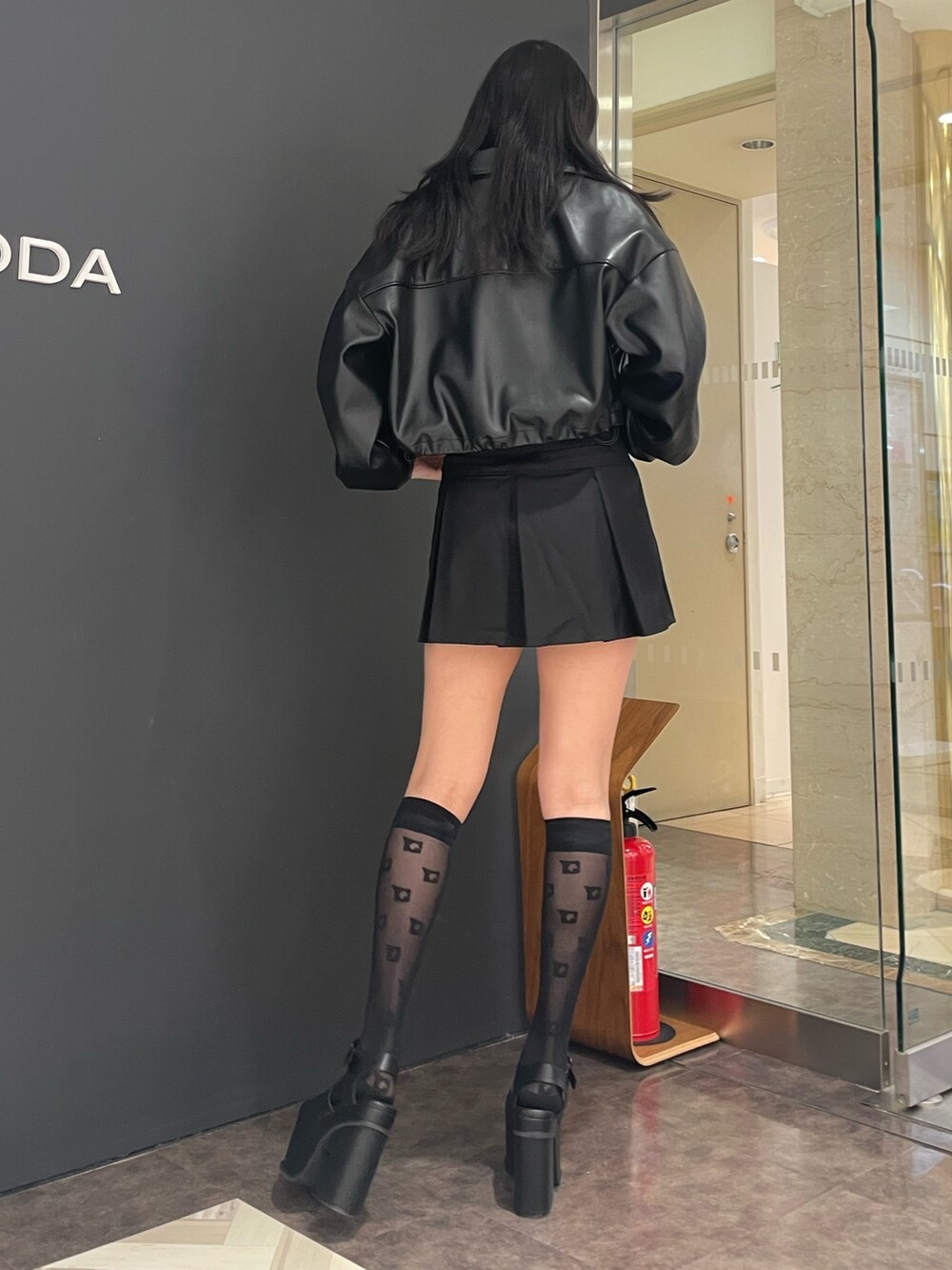 ホワイト系のタンクトップ、ブラック系のブルゾン、ブラック系のスカートを着用したレディースの春コーディネートの3枚目の写真