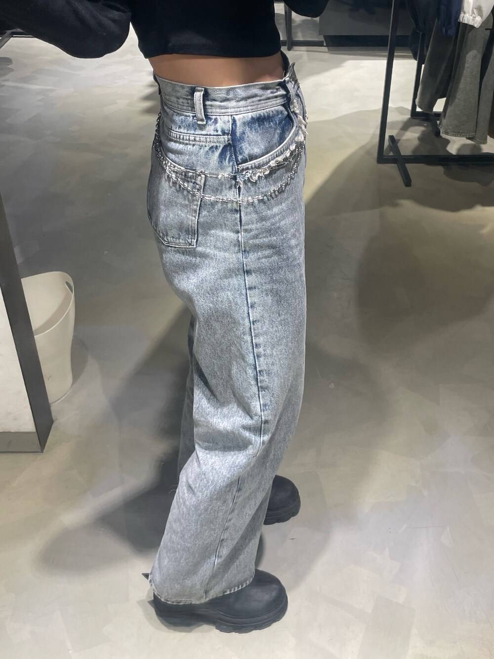 ブラック系のTシャツ/カットソー、ブルー系のデニムパンツ、ブラック系のブーツを着用したレディースの春コーディネートの7枚目の写真