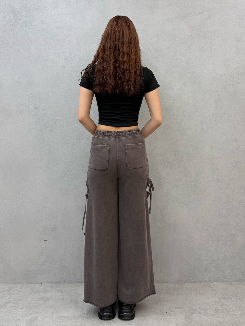 ブラック系のTシャツ/カットソー、ブラウン系のスウェットパンツ、ブラック系のサンダルを着用したレディースの夏コーディネートの3枚目の写真