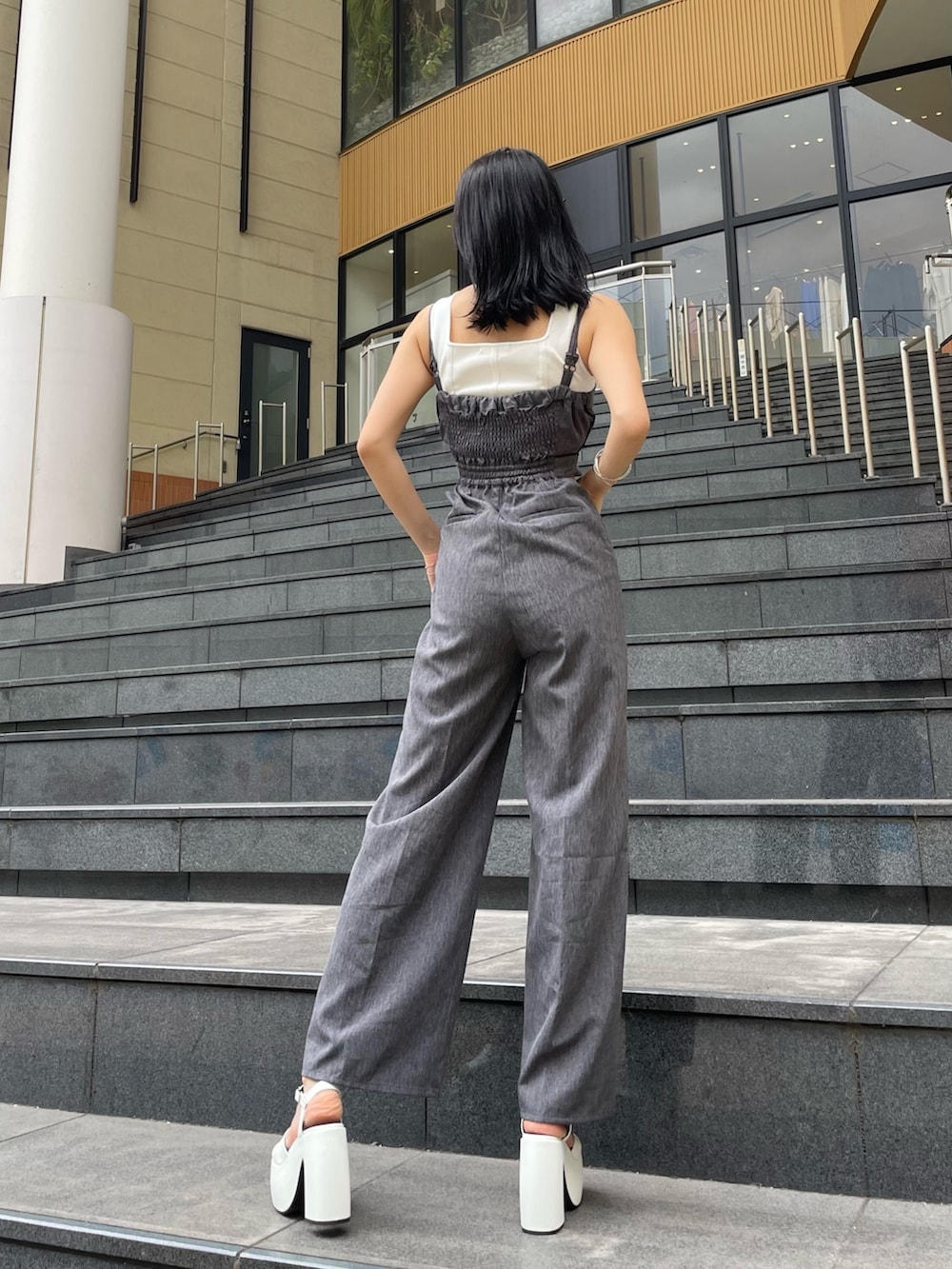 グレー系のサロペット/オーバーオール、ホワイト系のタンクトップ、ホワイト系のサンダルを着用したレディースの夏コーディネートの2枚目の写真