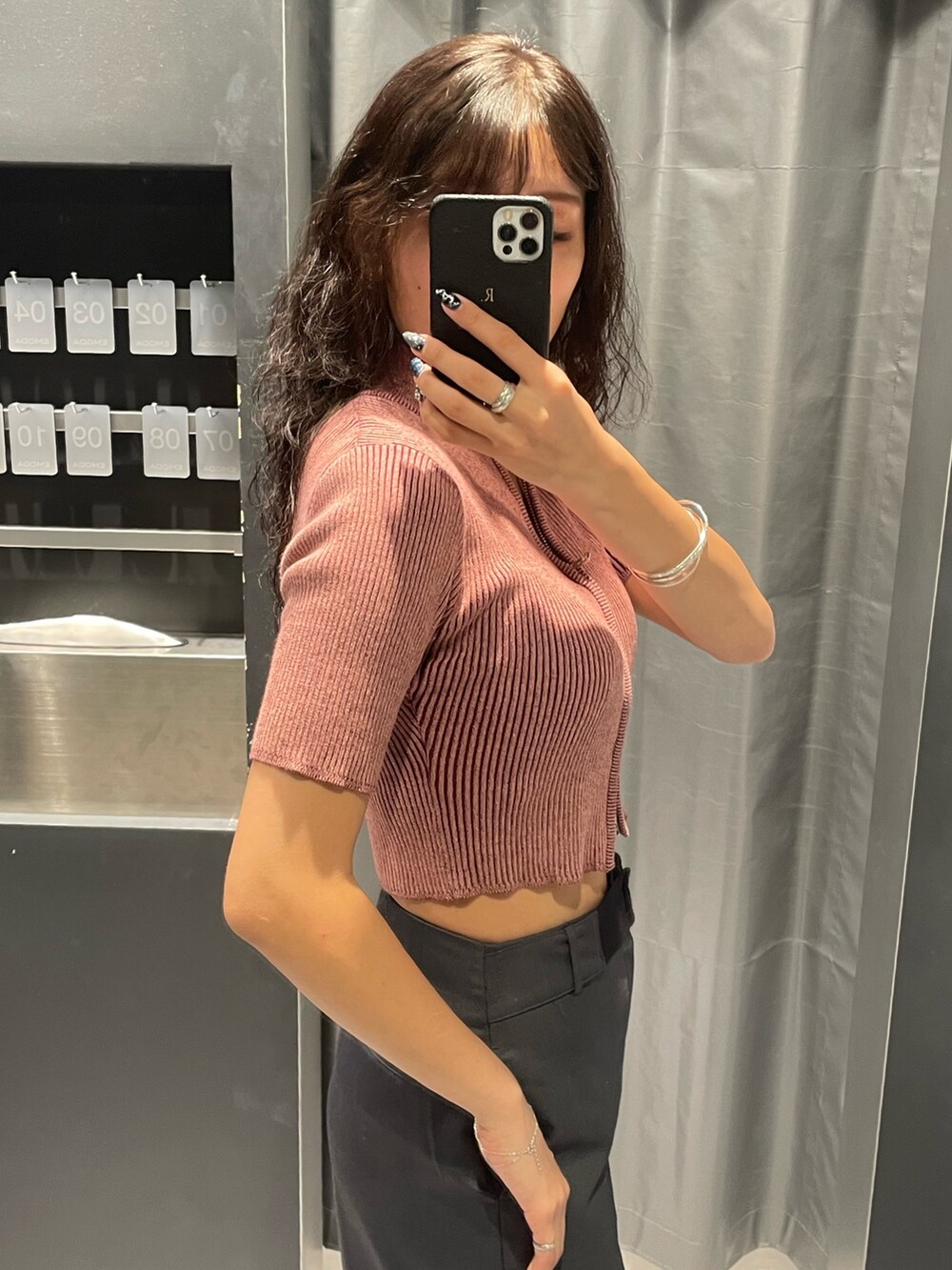 ピンク系のニット/セーター、グレー系のスカート、ブラック系のハンドバッグを着用したレディースの夏コーディネートの5枚目の写真