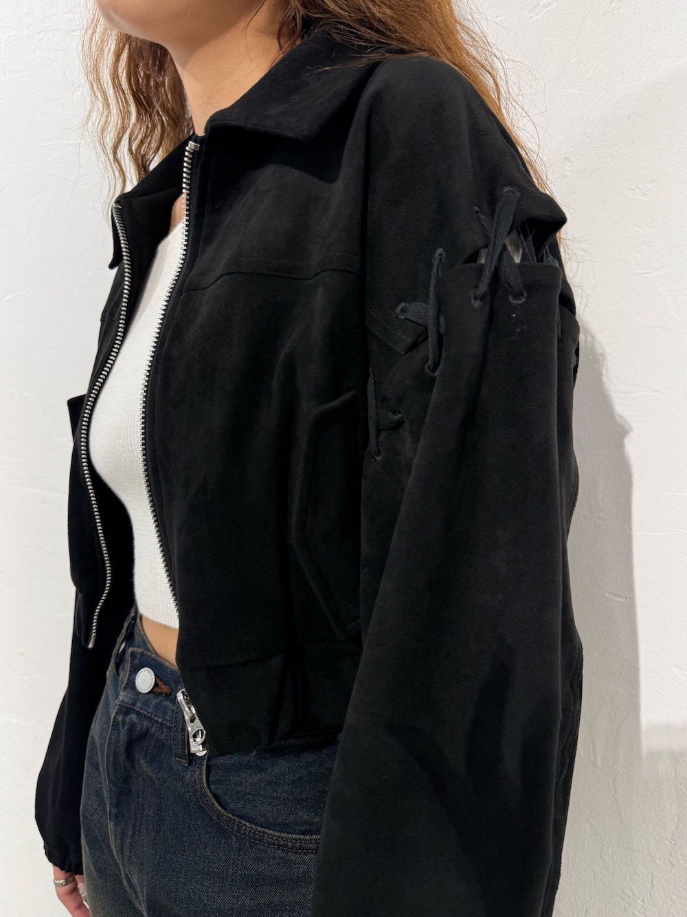 ホワイト系のニット/セーター、ブラック系のブルゾン、ブルー系のデニムパンツを着用したレディースの秋コーディネートの5枚目の写真