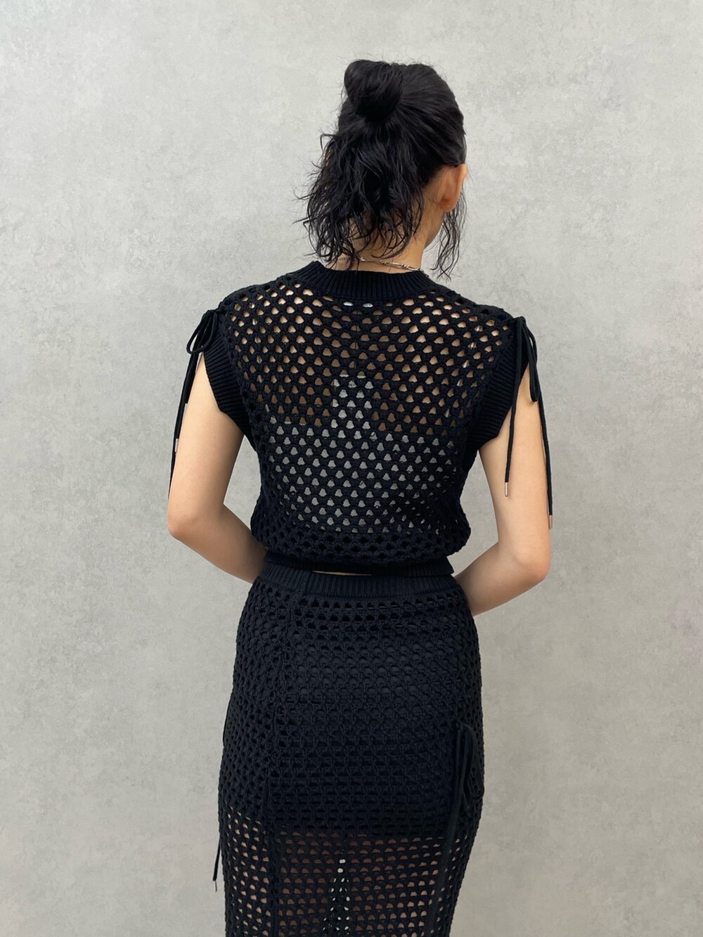 ホワイト系のキャミソール、ブラック系のタンクトップ、ブラック系のスカートを着用したレディースの春コーディネートの6枚目の写真