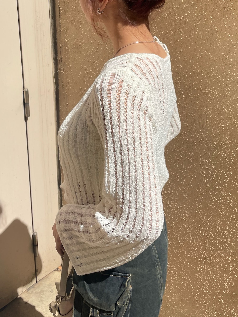 ホワイト系のニット/セーター、ブルー系のその他パンツ、ホワイト系のハンドバッグを着用したレディースの春コーディネートの5枚目の写真