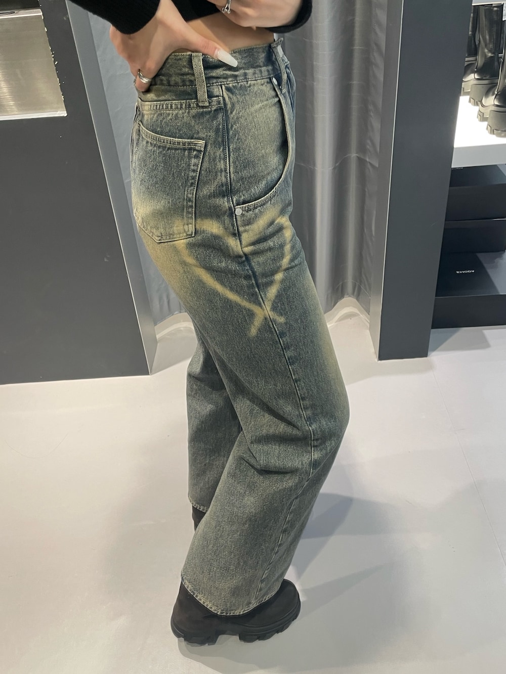 ブラック系のニット/セーター、ブルー系のデニムパンツ、ブラック系のブーツを着用したレディースの冬コーディネートの8枚目の写真