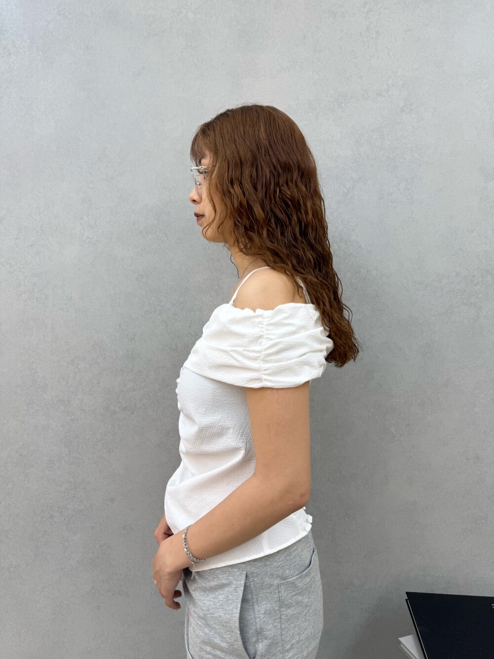 ホワイト系のTシャツ/カットソー、グレー系のスカート、ブラック系のサンダルを着用したレディースの夏コーディネートの5枚目の写真