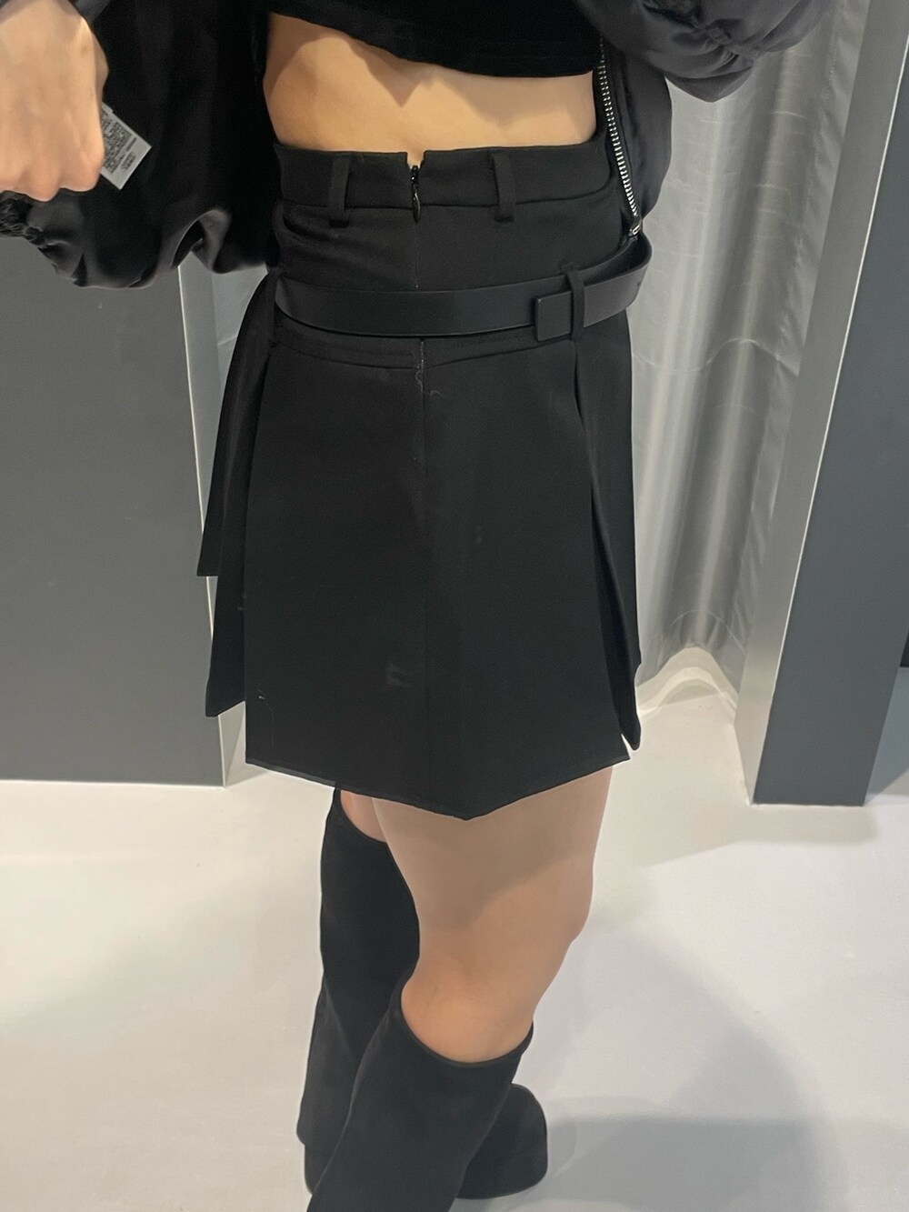 グレー系のニット/セーター、ブラック系のスカート、ブラック系のハンドバッグを着用したレディースの冬コーディネートの7枚目の写真