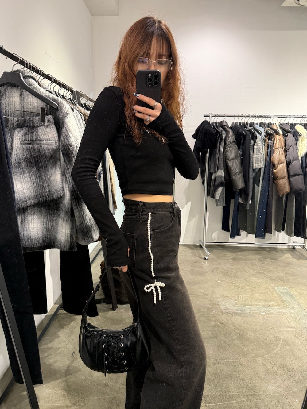 ブラック系のTシャツ/カットソー、ブラック系のデニムパンツ、ブラック系のショルダーバッグを着用したレディースの秋コーディネートの5枚目の写真