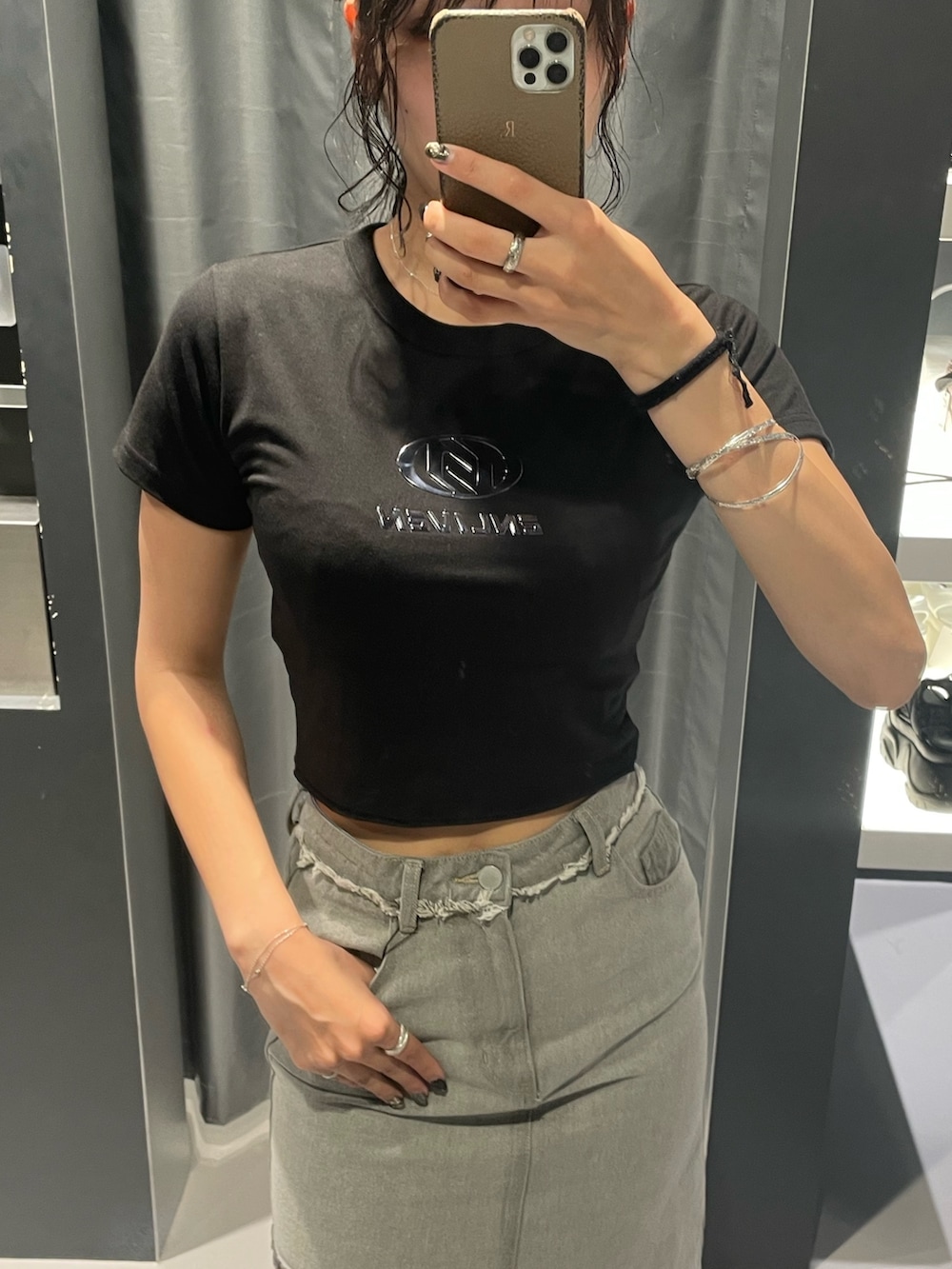 ブラック系のTシャツ/カットソー、グレー系のデニムスカート、ブラック系のサンダルを着用したレディースの夏コーディネートの3枚目の写真