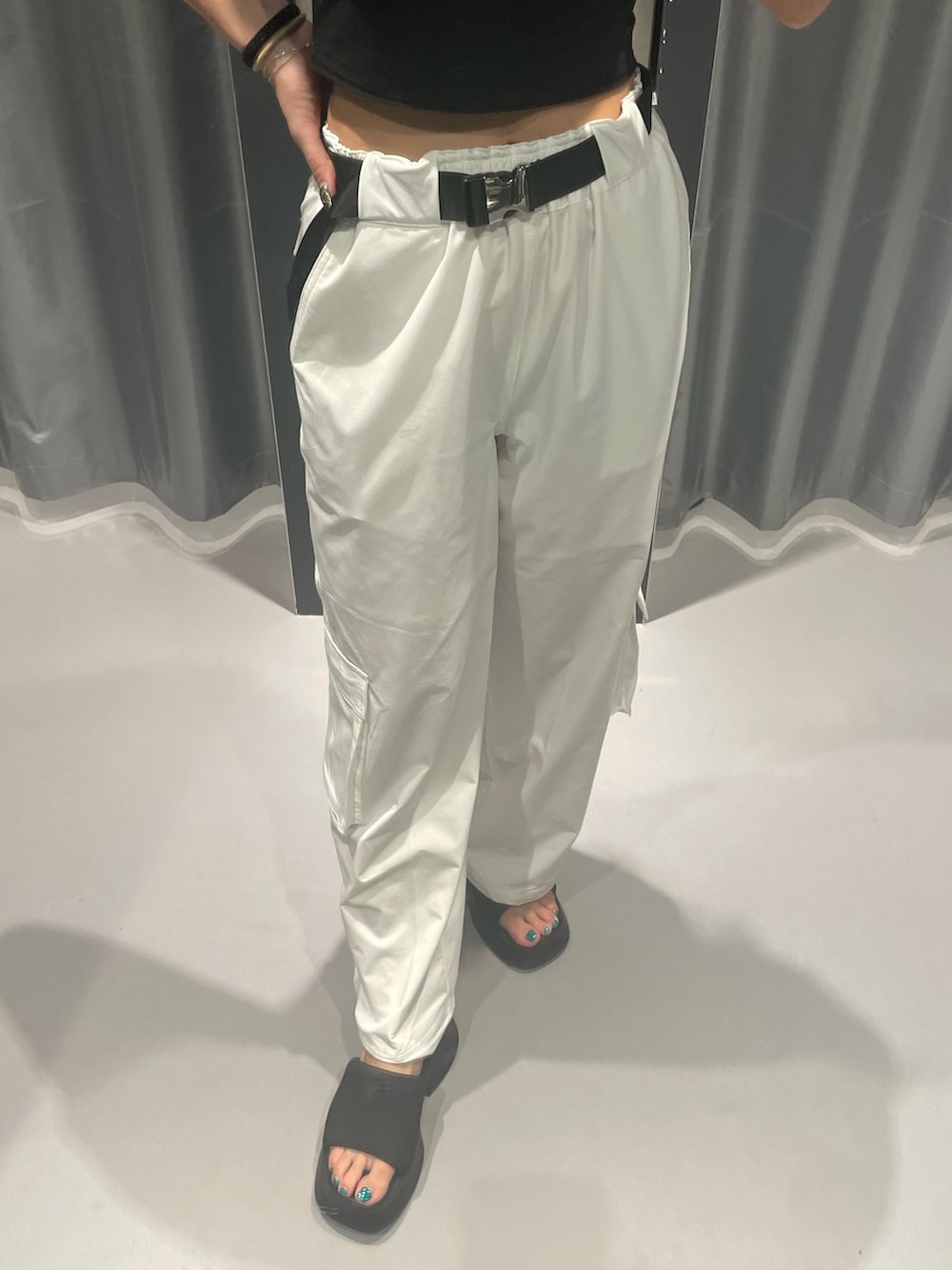 ブラック系のTシャツ/カットソー、ホワイト系のカーゴパンツ、ブラック系のサンダルを着用したレディースの夏コーディネートの6枚目の写真