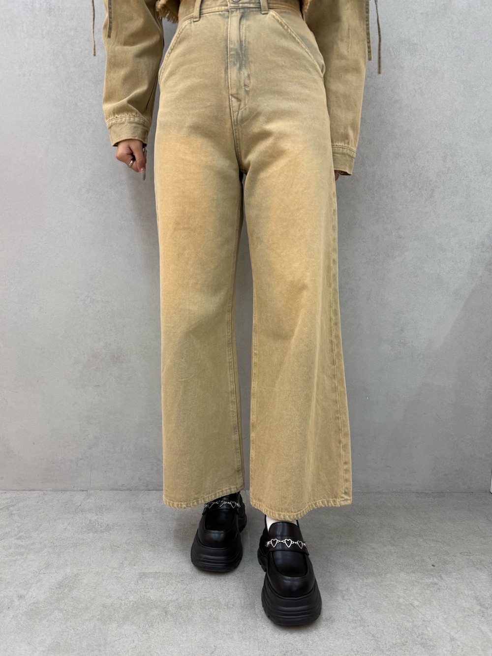 ブラック系のTシャツ/カットソー、ベージュ系のデニムパンツ、ブラック系のローファーを着用したレディースの冬コーディネートの5枚目の写真