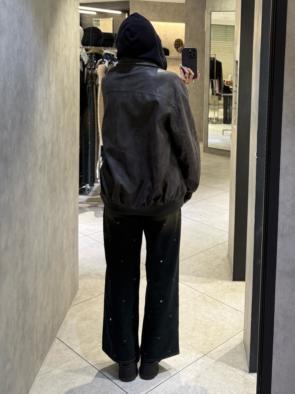 ブラック系のパーカー、グレー系のブルゾン、ブルー系のデニムパンツを着用したレディースの秋コーディネートの3枚目の写真