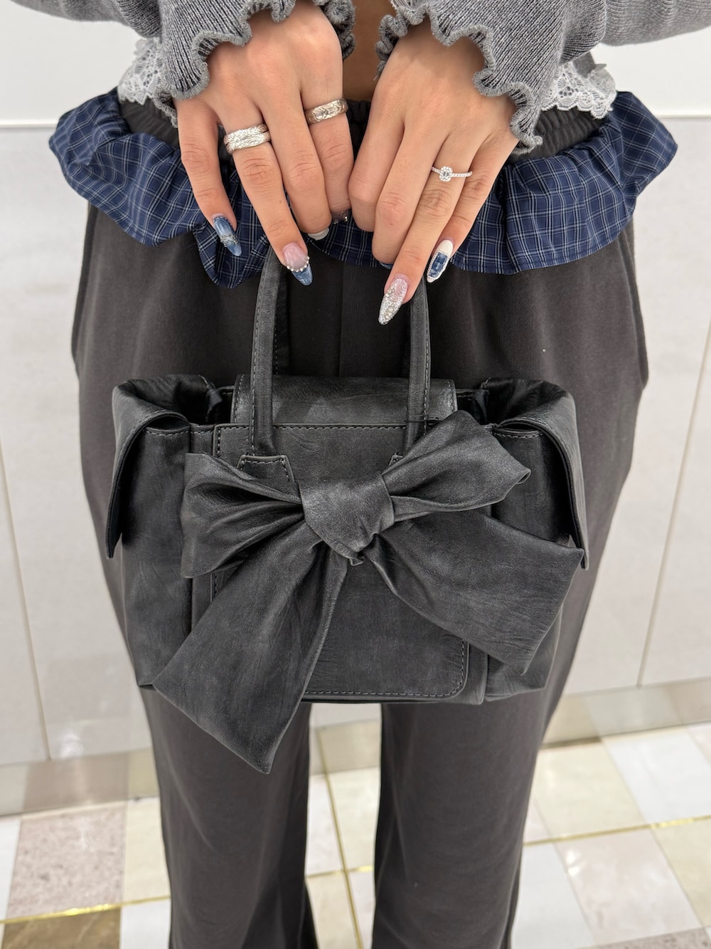 グレー系のニット/セーター、グレー系のスウェットパンツ、ブラック系のハンドバッグを着用したレディースの春コーディネートの5枚目の写真