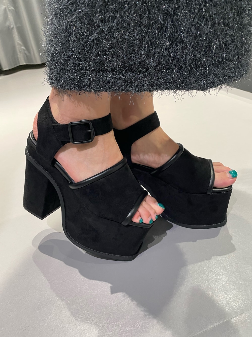 ブラック系のTシャツ/カットソー、グレー系のスカート、ブラック系のサンダルを着用したレディースの夏コーディネートの8枚目の写真