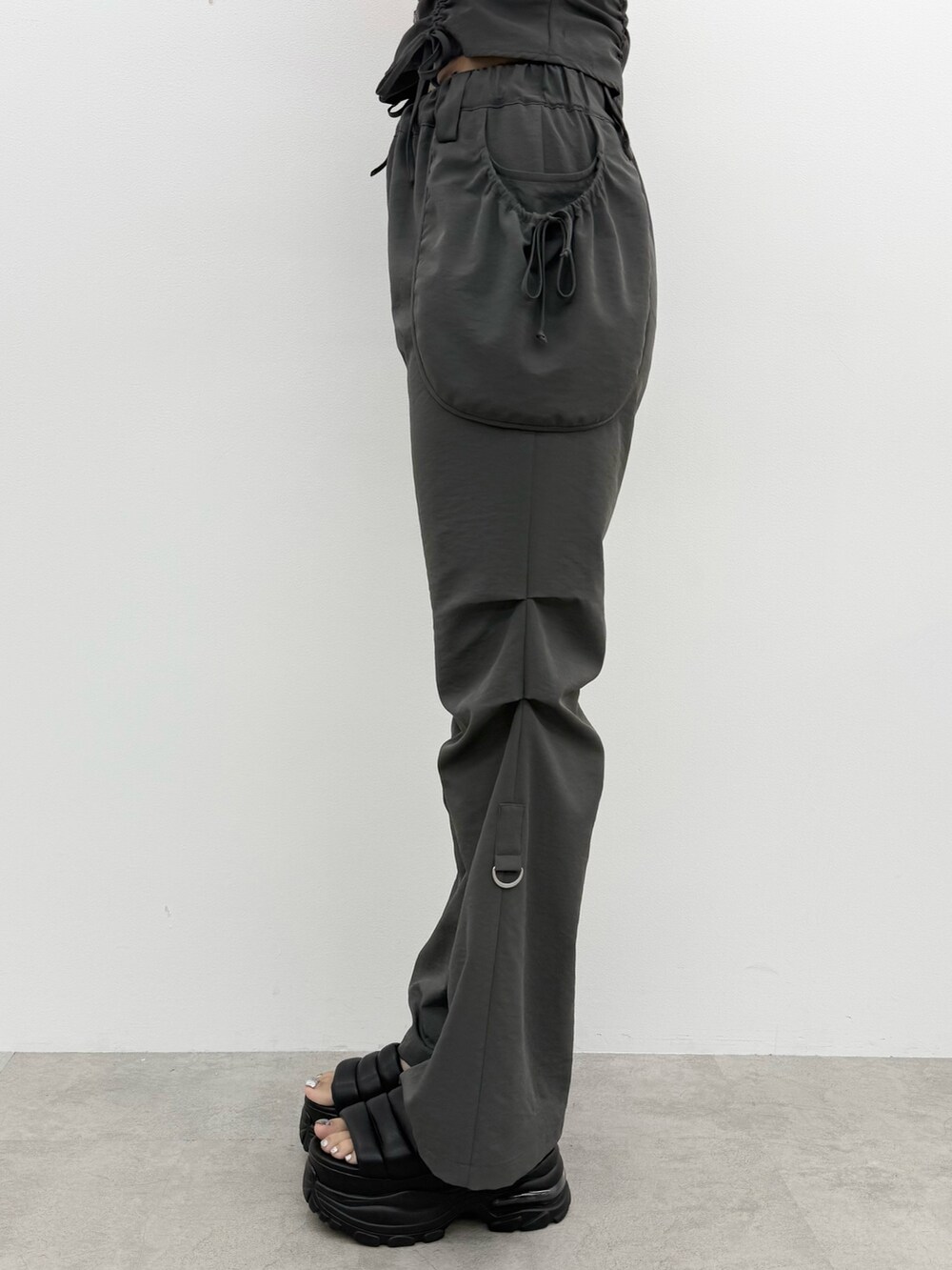 ブラック系のTシャツ/カットソー、グレー系のその他パンツ、ブラック系のハンドバッグを着用したレディースの夏コーディネートの8枚目の写真