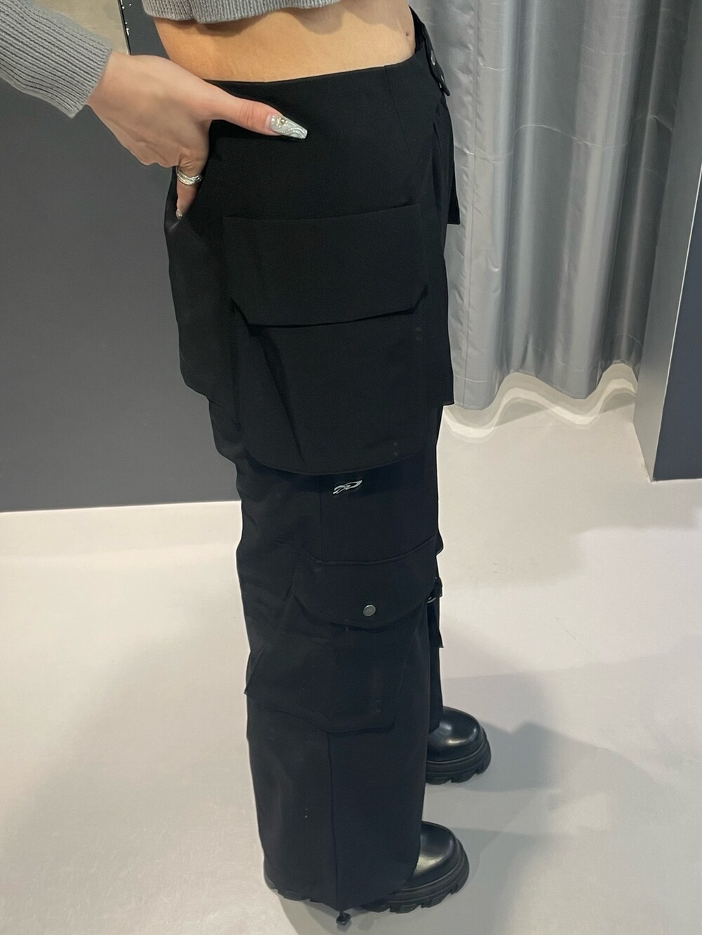 グレー系のニット/セーター、ブラック系のその他パンツ、ブラック系のブーツを着用したレディースの冬コーディネートの7枚目の写真