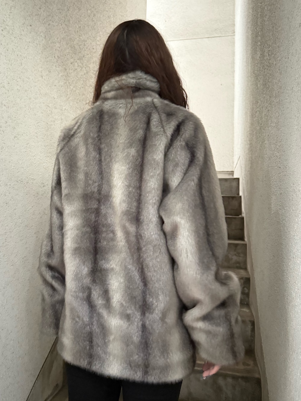 グレー系のその他アウター、ブラック系のデニムパンツ、ブラック系のブーツを着用したレディースの秋コーディネートの5枚目の写真