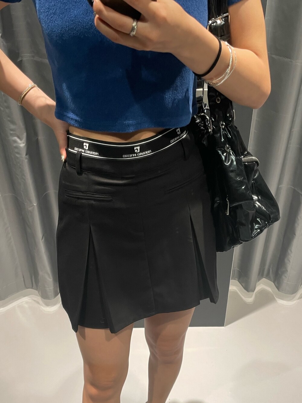 ブルー系のTシャツ/カットソー、ブラック系のハンドバッグ、ブラック系のスカートを着用したレディースの夏コーディネートの6枚目の写真