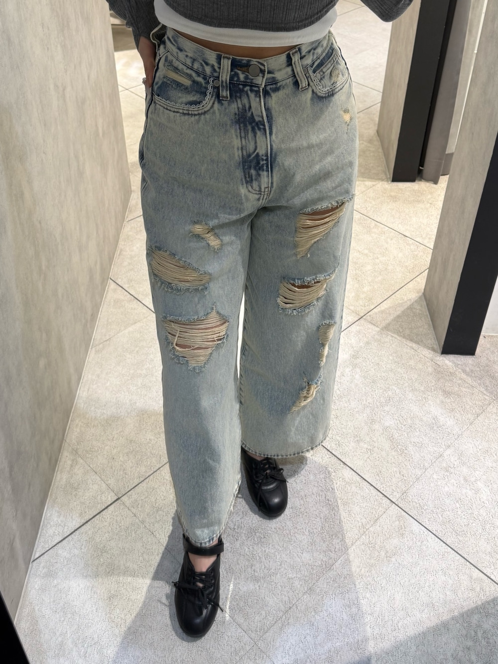 グレー系のTシャツ/カットソー、ブルー系のデニムパンツ、ブラック系のスニーカーを着用したレディースの春コーディネートの5枚目の写真