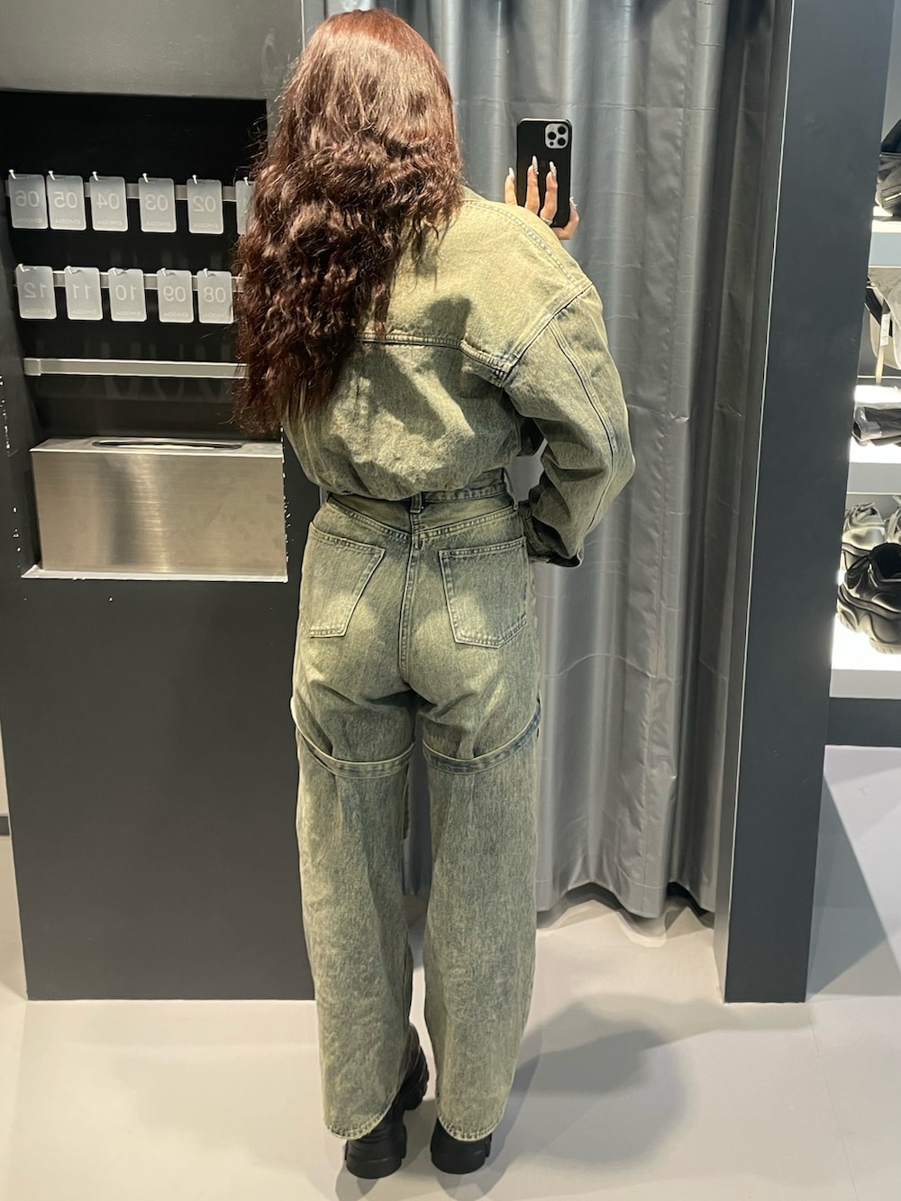 ブラック系のニット/セーター、ブルー系のデニムジャケット、ブルー系のデニムパンツを着用したレディースの冬コーディネートの3枚目の写真