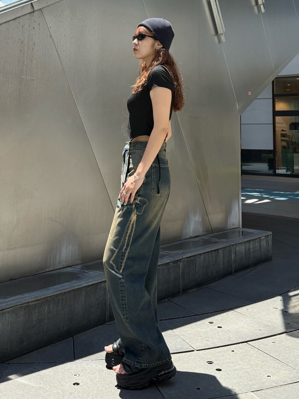 ブラック系のTシャツ/カットソー、ブルー系のデニムパンツ、ブラック系のサンダルを着用したレディースの夏コーディネートの2枚目の写真