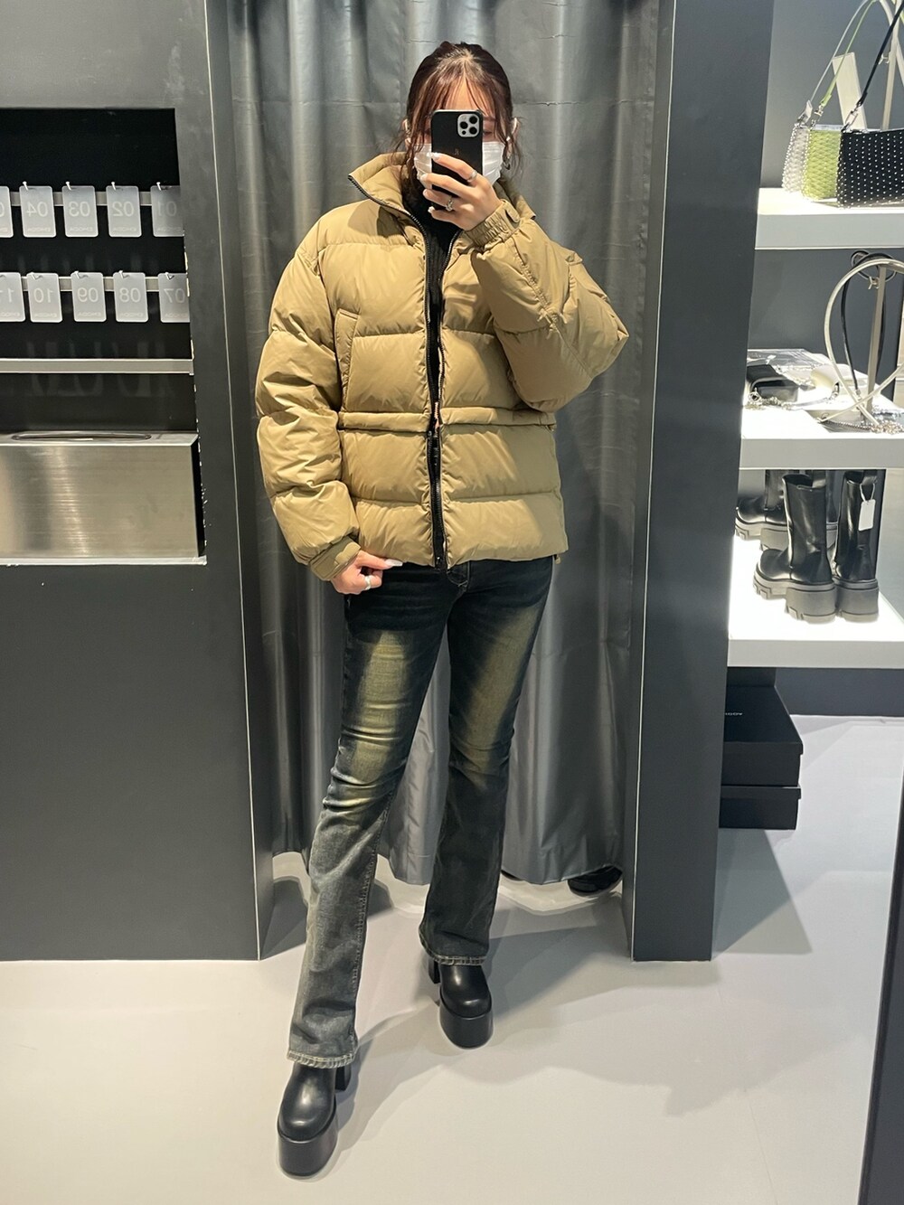 ブラック系のニット/セーター、ベージュ系のブルゾン、ブルー系のデニムパンツを着用したレディースの冬コーディネートの4枚目の写真