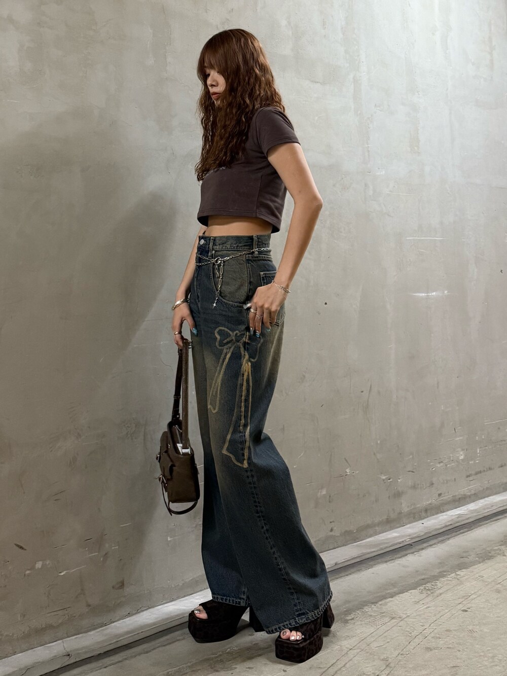 ブラウン系のTシャツ/カットソー、ブルー系のデニムパンツ、ブラウン系のサンダルを着用したレディースの夏コーディネートの2枚目の写真