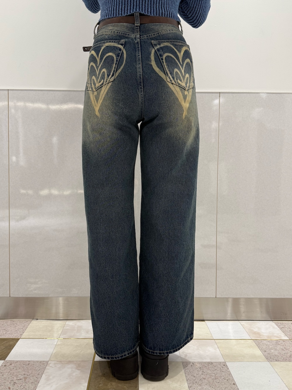 ブルー系のニット/セーター、ブルー系のデニムパンツ、ブラック系のブーツを着用したレディースの冬コーディネートの7枚目の写真